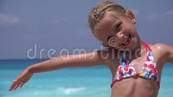 海滩上的4K孩子海上嬉戏的快乐儿童肖像海岸线上的儿童微笑欢笑的小女孩视频的预览图
