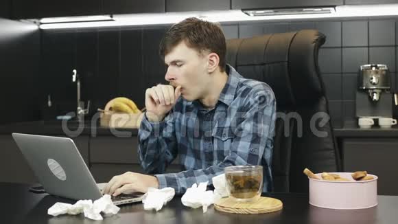 感冒咳嗽和打喷嚏的病人在家工作生病的男性在家里用笔记本电脑工作不舒服的男人视频的预览图