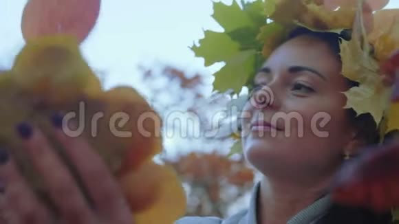 特写镜头美丽的女人在迪丽娃的秋叶和微笑中头上有一呼吸视频的预览图