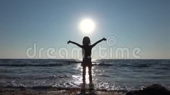 4K孩子在阳光海岸的海滩上玩耍阳光海岸的剪影女孩在海边的夏季景观视频的预览图