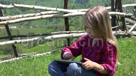 4K孩子在餐桌上玩耍孩子在草地上玩耍女孩在山区旅行时使用工作智能手机视频的预览图