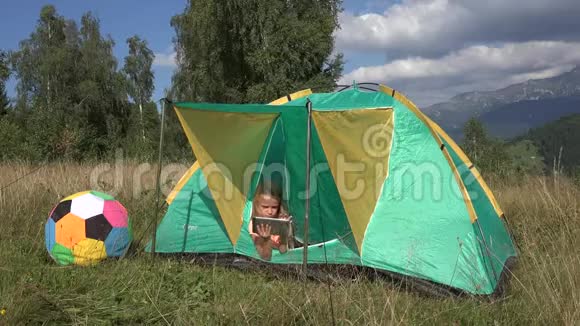 4K小子在玩平板电脑儿童在帐篷女孩在露营在山区儿童户外在大自然视频的预览图