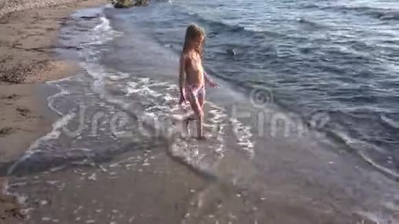 4K孩子在海滩上玩耍孩子在海岸上奔跑女孩在海岸上行走的海浪视频的预览图