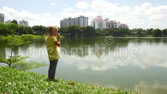 一个女孩正在池塘里寻找鱼视频的预览图