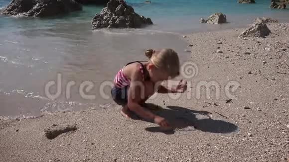 4K孩子在沙滩上画画孩子在海边玩耍女孩在海浪中洗澡视频的预览图