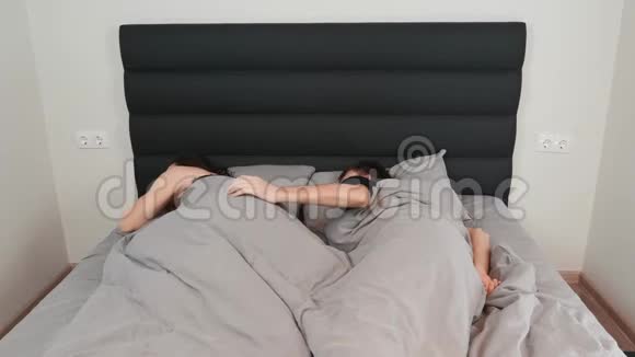 幸福的年轻夫妇睡在床上恋爱中的女人和男人躺在床上拥抱关系概念视频的预览图