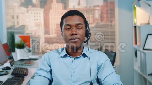 戴着耳机对着镜头微笑的黑人客户服务经营者画像视频的预览图