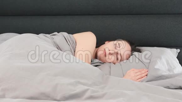 一个人睡在床上的女人孤独的年轻女性正睡在空荡荡的客厅里生活方式概念视频的预览图