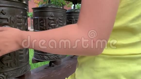 白种人男孩触摸旋转尼泊尔传统金属祈祷轮与咒语OManiPadmeHum这意味着O视频的预览图
