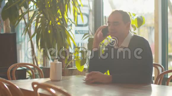 男人坐在咖啡馆里打电话视频的预览图