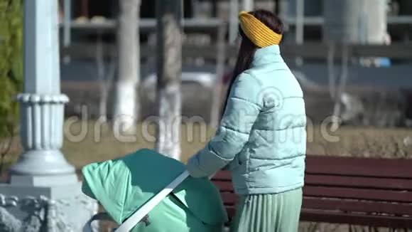 带着婴儿车穿过公园的女人视频的预览图