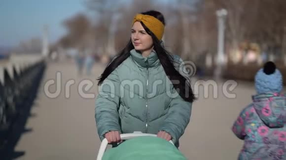 带着婴儿车穿过公园的女人视频的预览图