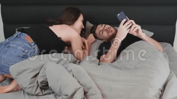 迷人的黑发妻子在床上和她年轻的丈夫调情年轻迷人的女人和躺在床上的男人调情结婚快乐视频的预览图