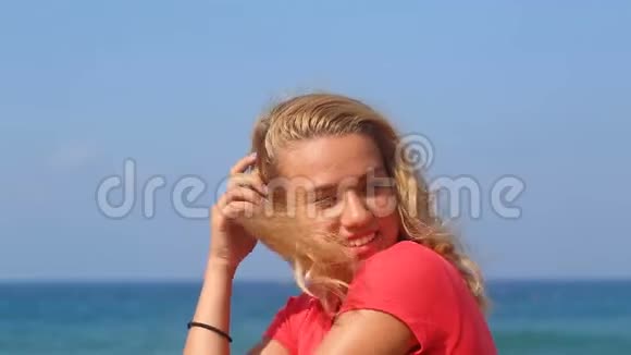 年轻漂亮的女孩坐在海边视频的预览图
