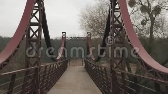 性感的男运动员在户外过桥穿着黑色运动服装的白人男子在公园的河对岸桥上慢跑视频的预览图