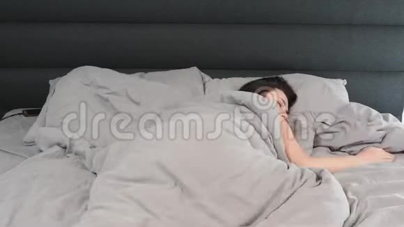 女性睡在空床上的时间推移年轻的白种人黑发女人闭着眼睛躺在床上视频的预览图