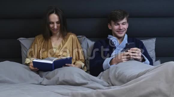 已婚夫妇晚上躺在床上一对微笑的夫妇躺在床上恋爱关系恋爱中的情侣视频的预览图