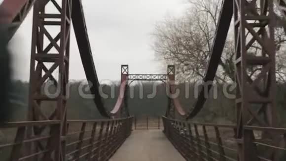 公园里男子运动员在跨河大桥上奔跑的背面景色早上慢跑的年轻人高加索人逃跑视频的预览图