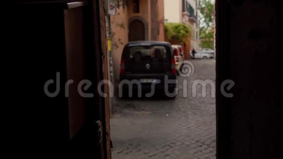 迷人的女孩沿着一条古老的城市街道走过一个位于门口的照相机意大利罗马视频的预览图