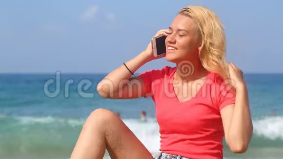 年轻漂亮的女孩在大海的背景下打电话视频的预览图