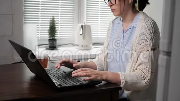 自由职业者程序员编码器黑客通信社交网络概念带眼镜的漂亮女人在厨房里视频的预览图