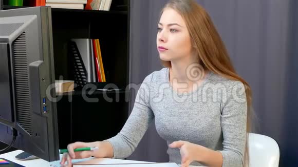 一个女人用钢笔从电脑显示器上重写数据视频的预览图