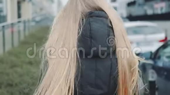 年轻的金发女人戴着医疗面具从街上的人身上逃跑视频的预览图