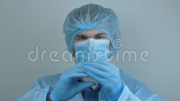 男性医生持注射器注射用药物的肖像柯维德19冠状病毒的大流行保护病毒防护视频的预览图