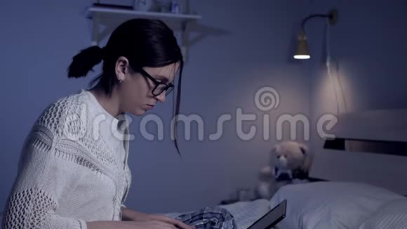 女孩晚上在笔记本电脑上工作漂亮的年轻女性自由职业者或带眼镜的学生头上戴马尾辫视频的预览图