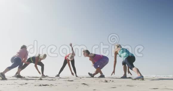 年长的女人在海滩上伸展视频的预览图