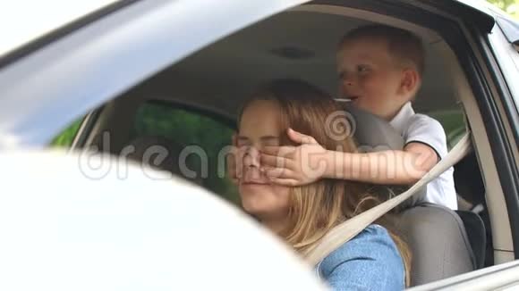 一个小男孩开车时闭上了母亲眼睛视频的预览图
