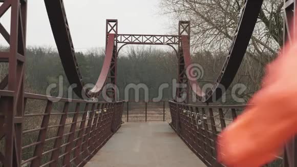 在帕克兰一对年轻的运动夫妇在桥上奔跑穿着鲜艳运动装慢跑的男女运动员视频的预览图