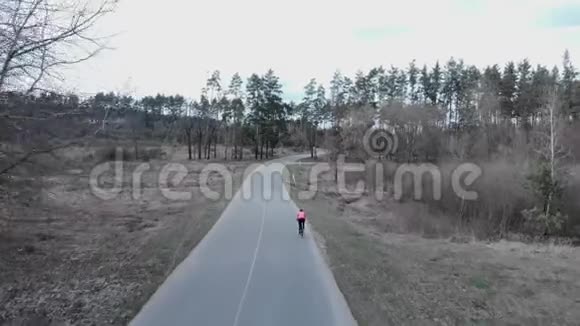骑自行车的人在松树林的空公路上快速密集地骑着自行车BIC运动员艰苦训练的空中视野视频的预览图