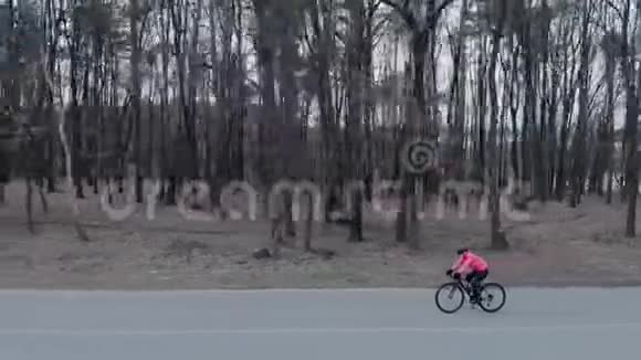 职业女自行车运动员独自骑自行车和训练女运动员在空车上集中蹬自行车视频的预览图