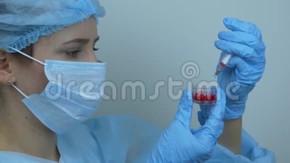 冠状病毒疫苗接种持有注射用预防性药物的注射器的保护性医疗器械中的女工视频的预览图