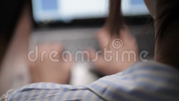 模糊的女手女孩晚上在笔记本电脑键盘上打字看着屏幕女青年自由职业者或视频的预览图