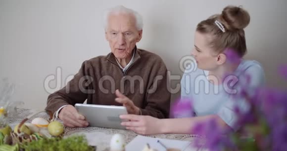 孙女和祖父使用数字平板电脑视频的预览图
