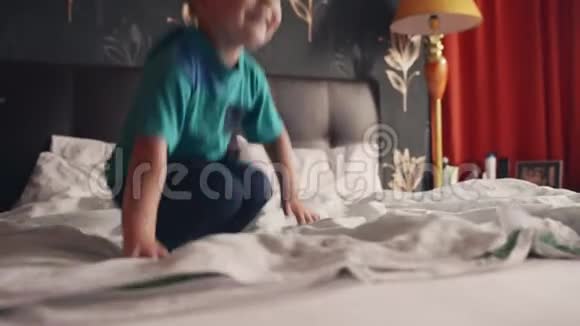 快乐的男孩在床上嬉戏视频的预览图