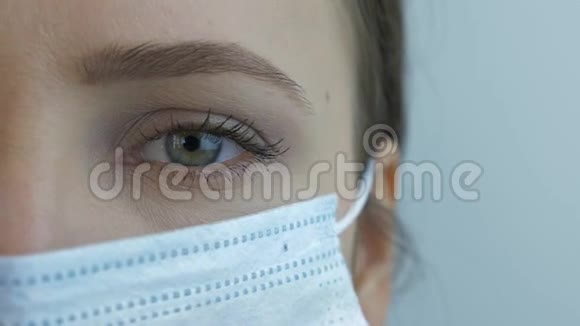 检疫期间戴着医用防护面罩的年轻美丽女子的画像戴医用蓝色口罩感染病毒的女孩视频的预览图