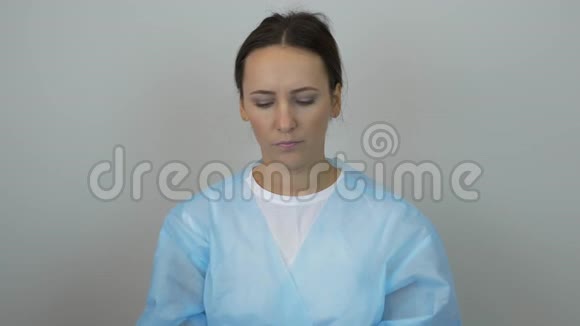 身穿医生制服和外科蓝手套的妇女戴上防护面罩准备接受外科治疗美容师放o视频的预览图