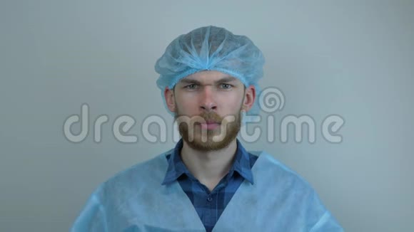 男医生在手术前戴上医用口罩穿着防护服的工人视频的预览图