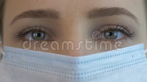 女性面部在医用口罩中进行病毒感染的预防和保护极致特写Covid的大规模保护视频的预览图