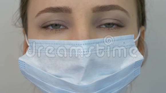 女戴防护医用蓝色口罩的脸特写年轻女性戴着预防病毒感染的医用口罩视频的预览图