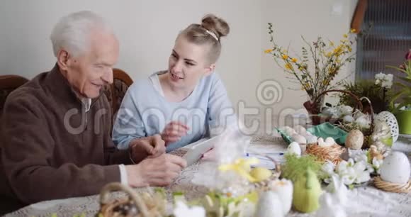 孙女和祖父使用数字平板电脑视频的预览图