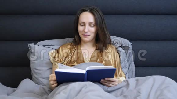 晚上穿内衣的女人睡觉前看书年轻迷人的女性晚上躺在床上布鲁内特躺在床上视频的预览图