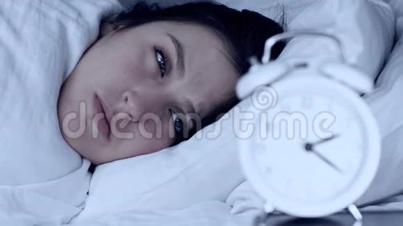 失眠焦虑问题概念晚上躺在床上的迷人的白人妇女看着闹钟看不到自己的倒下视频的预览图