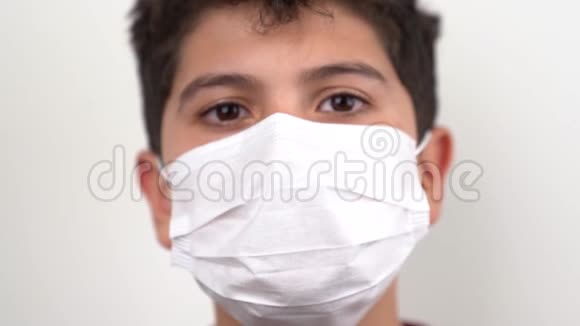 一个男孩戴上面具看着相机检疫图标科罗纳病毒Covid19视频的预览图