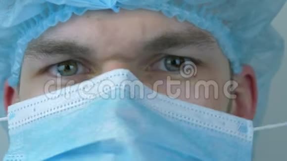 男医生在手术治疗前戴上保护性医用口罩穿着医用防护装备准备手术的人视频的预览图