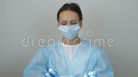 女医生在临床手术治疗前戴上医疗帽穿着军装戴防护面罩和l的妇女肖像视频的预览图