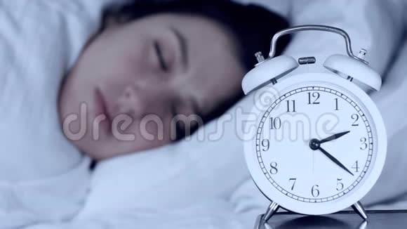 失眠焦虑问题的概念漂亮的白种人女孩晚上躺在床上看闹钟不能摔倒视频的预览图